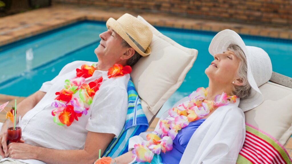 retired couple sun bathing relaxing on a cruise with sun hats and lais