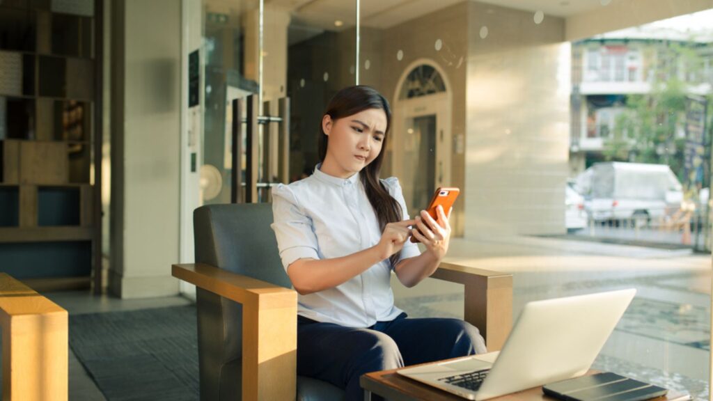 Woman using smartphone in cafe feel confuse