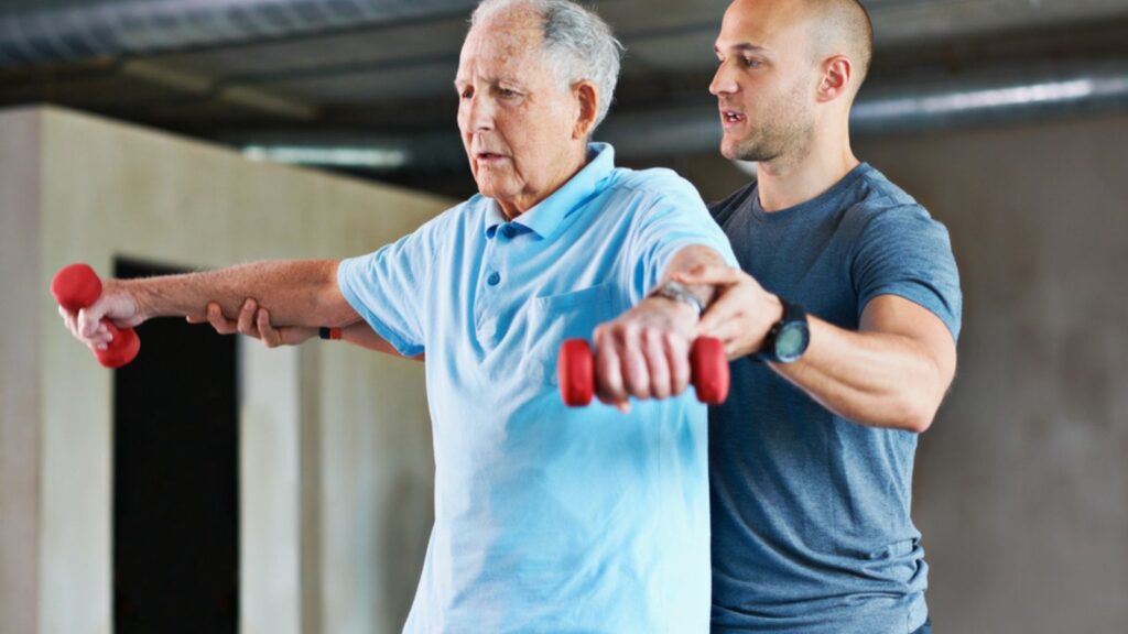 senior man Shot of a physiotherapist helping a senior man with weights.
