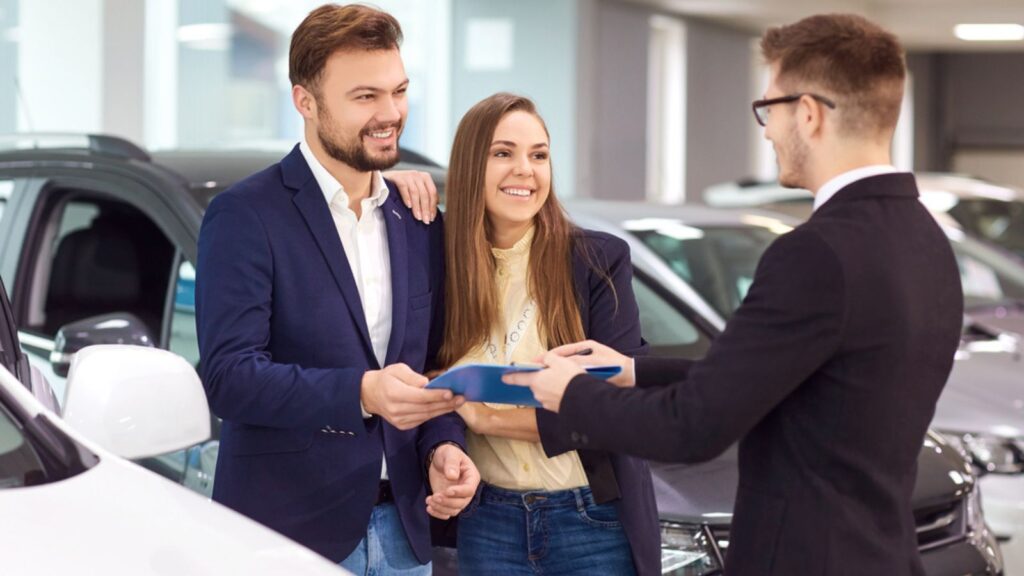 A car dealer sells cars to customers couple