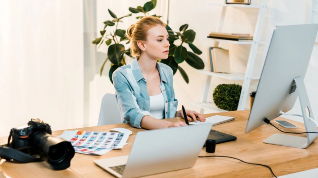 Beautiful woman working with desktop computer and drawing tablet