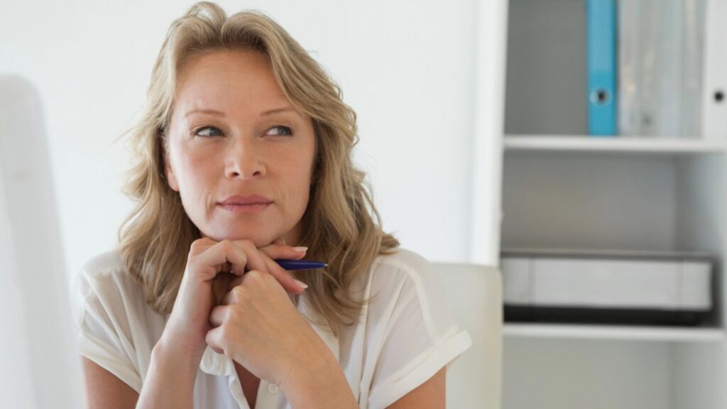 Casual businesswoman thinking at her desk