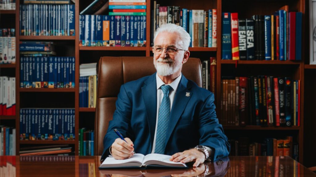 Experienced, confident, mature elderly old retired successful business man sitting at desk in library