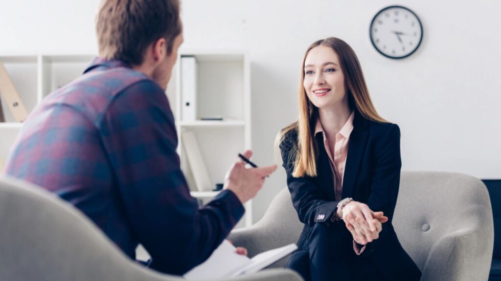 Happy businesswoman in suit giving interview to journalist in office.
