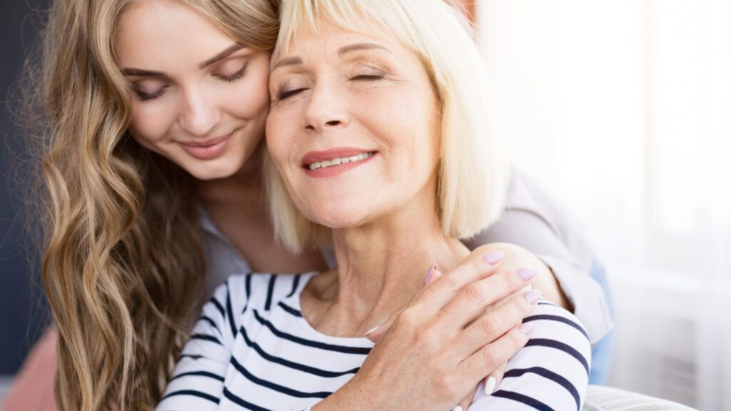 Happy young daughter embracing her mother with love