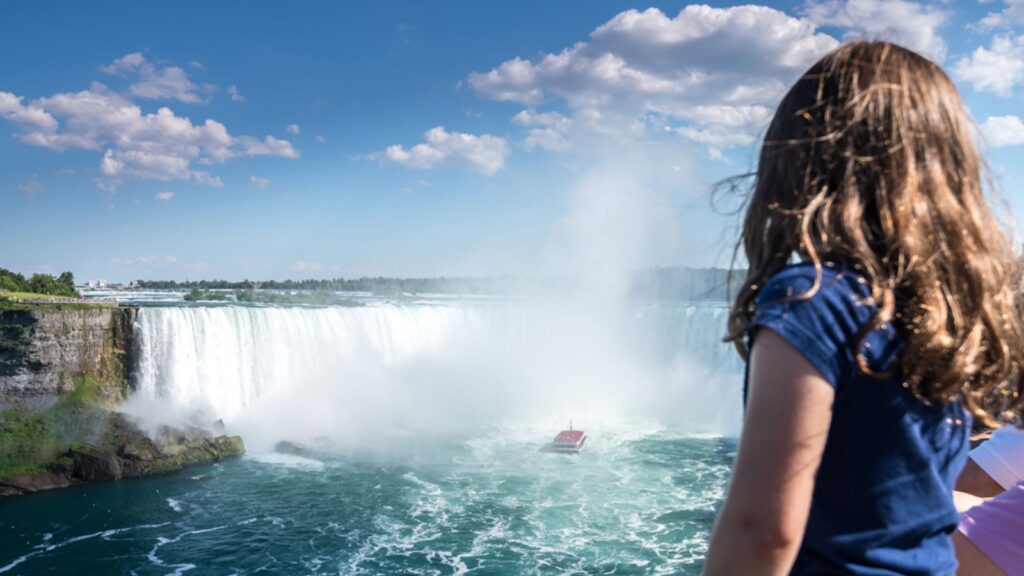 Little girl in Aerial shot of famous beautiful Niagara waterfall on summer day