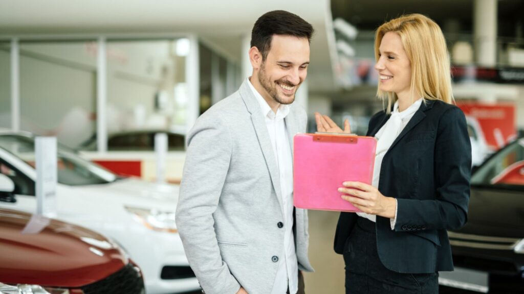 Salesperson showing vehicle to potential customer man