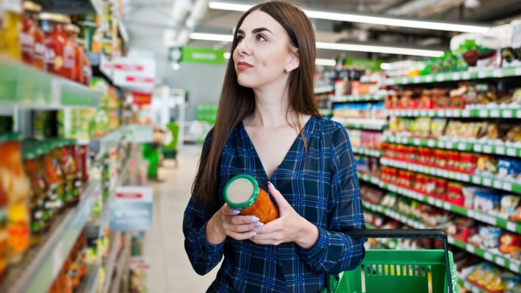 Shopping woman shopping the shelves in the supermarket canned