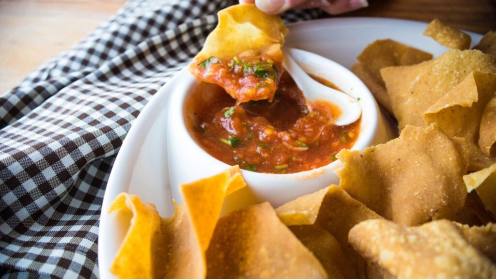 Spicy red salsa with a plate of tortilla chips