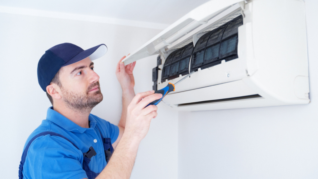 Technician man installing air conditioner on the wall at home for hvac service