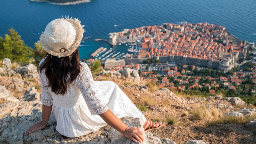 Traveller woman looking at view of Dubrovnik city, in Dalmatia, Croatia, the prominent travel destination of Croatia