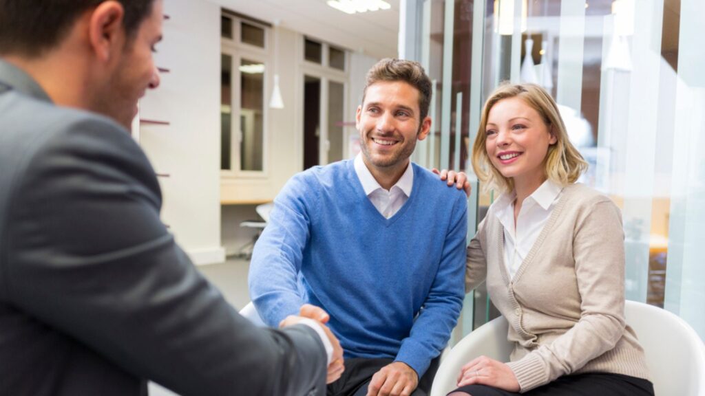 Young couple shaking hand to man agent in agency office