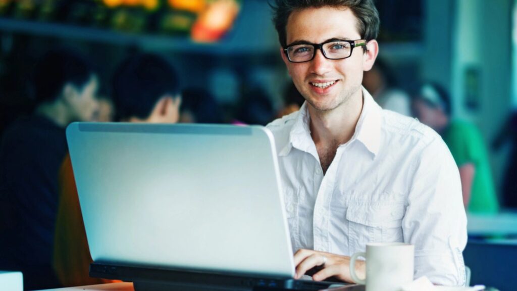 Young man working with his laptop on a restaurant