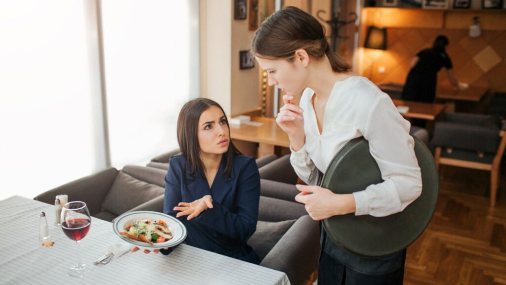 angry mad disappointed woman eating at restaurant upset with waitress waiter