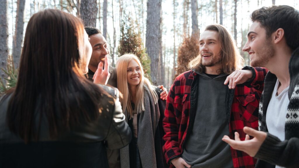 group of young people walking hiking in forest talking laughing