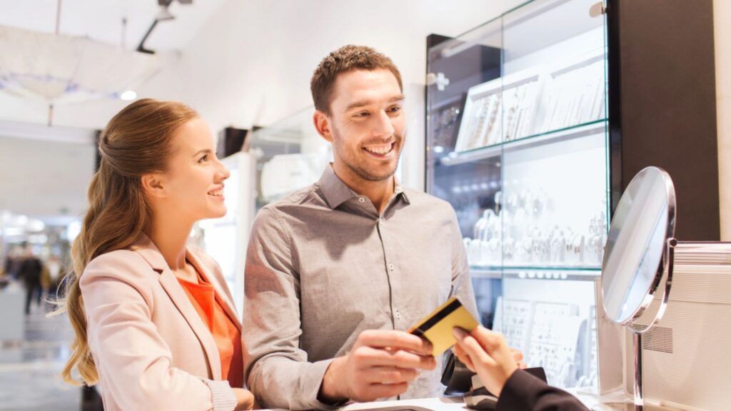 happy couple buying jewelry in store