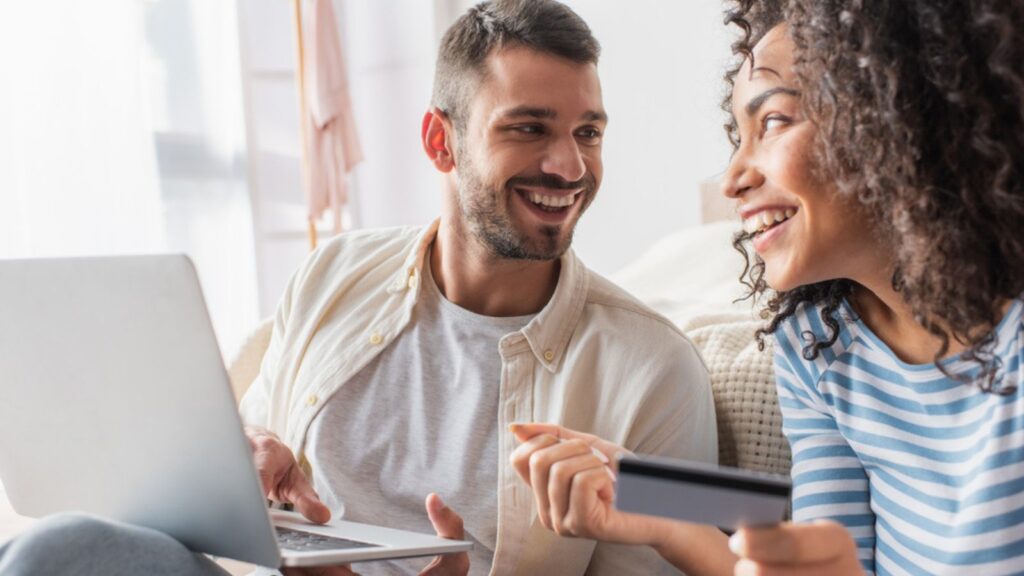 happy young couple shopping online using credit card