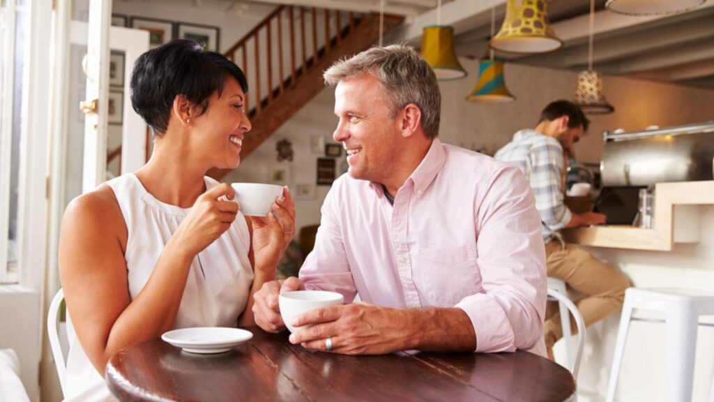 middle aged man and woman drinking coffee in cafe