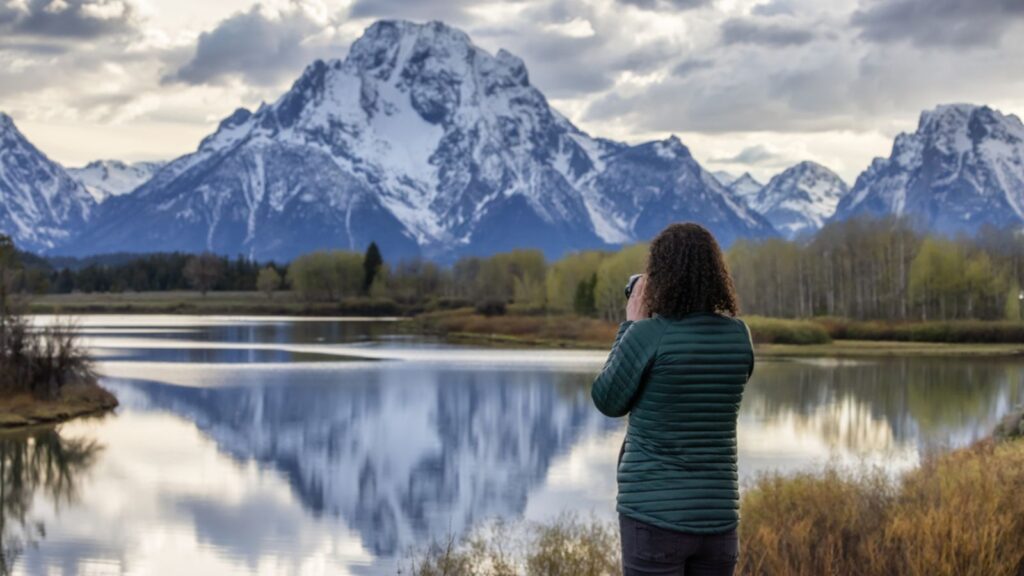 traveler tourist woman photographer taking pictures of mountains grand teton national park wyoming
