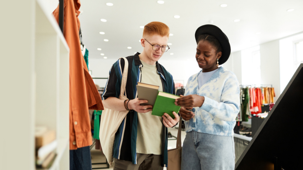 two young friends looking at used antique thrift shop books and items to buy purchase
