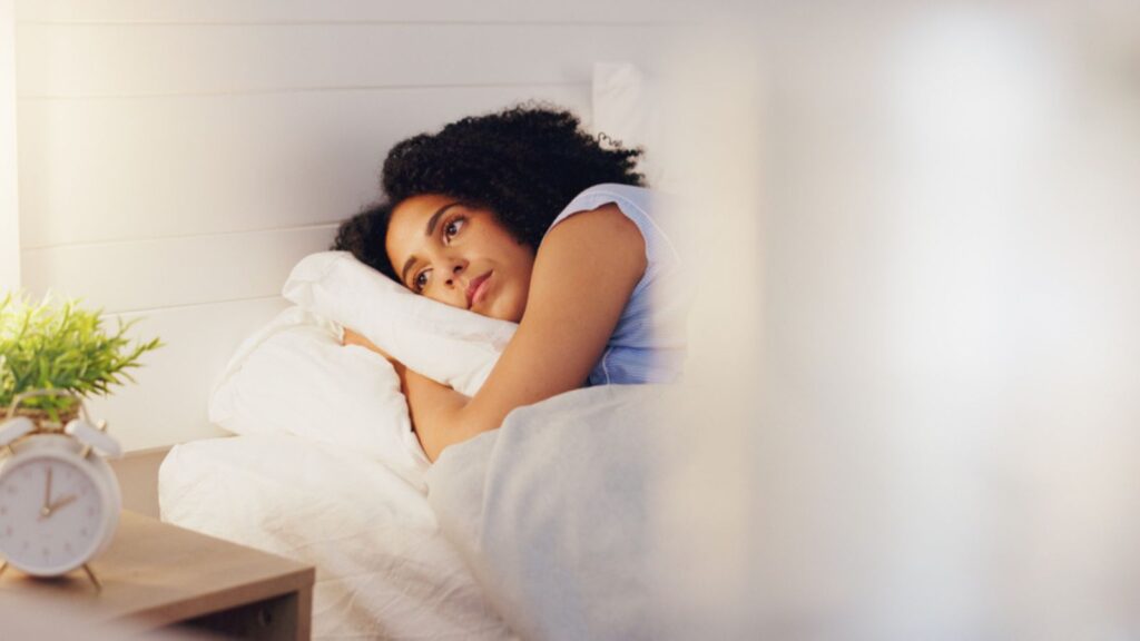 woman awake laying in bed insomnia can't sleep dreaming