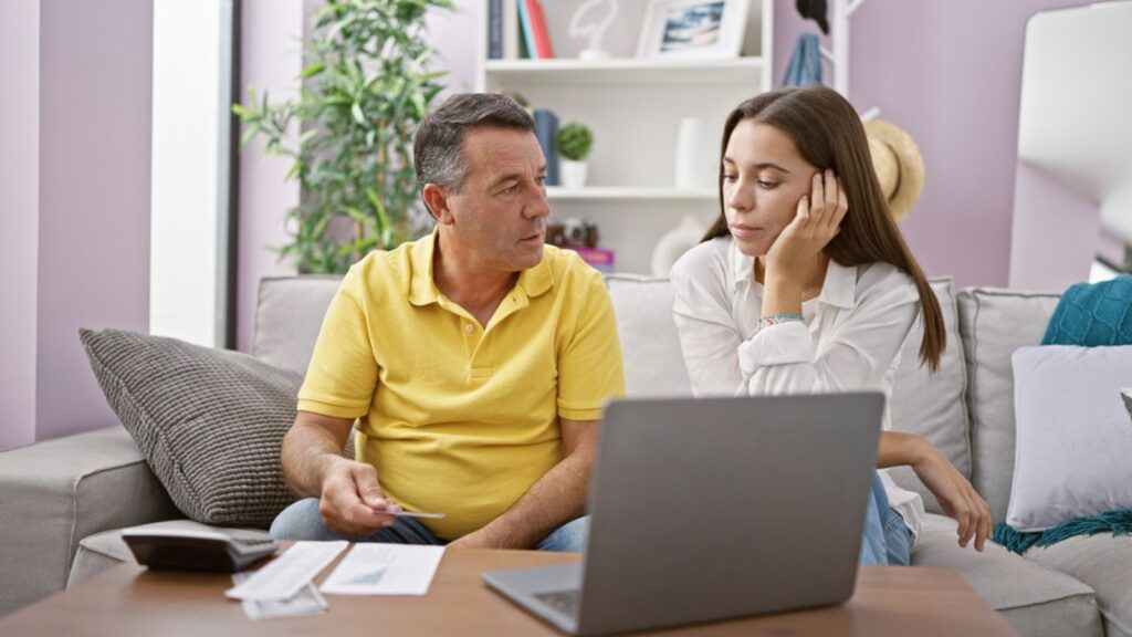 worried stressed young woman and father budgeting financial planning