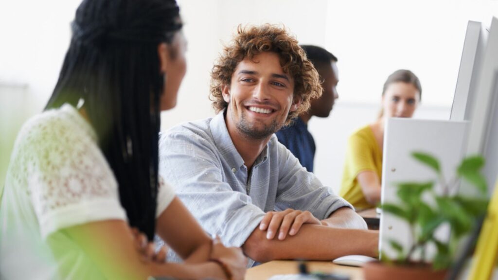 young couple talking smiling laughing at cafe or office