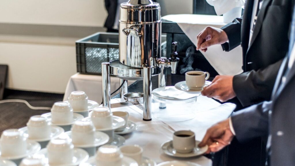 Abstract blurred many rows of coffee tea cups with coffee dispenser business people taking one