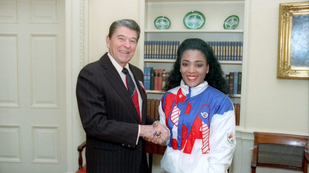 C50027-6, President Reagan greeting Florence Griffith Joyner of the U.S. Olympic team in the Oval Office.