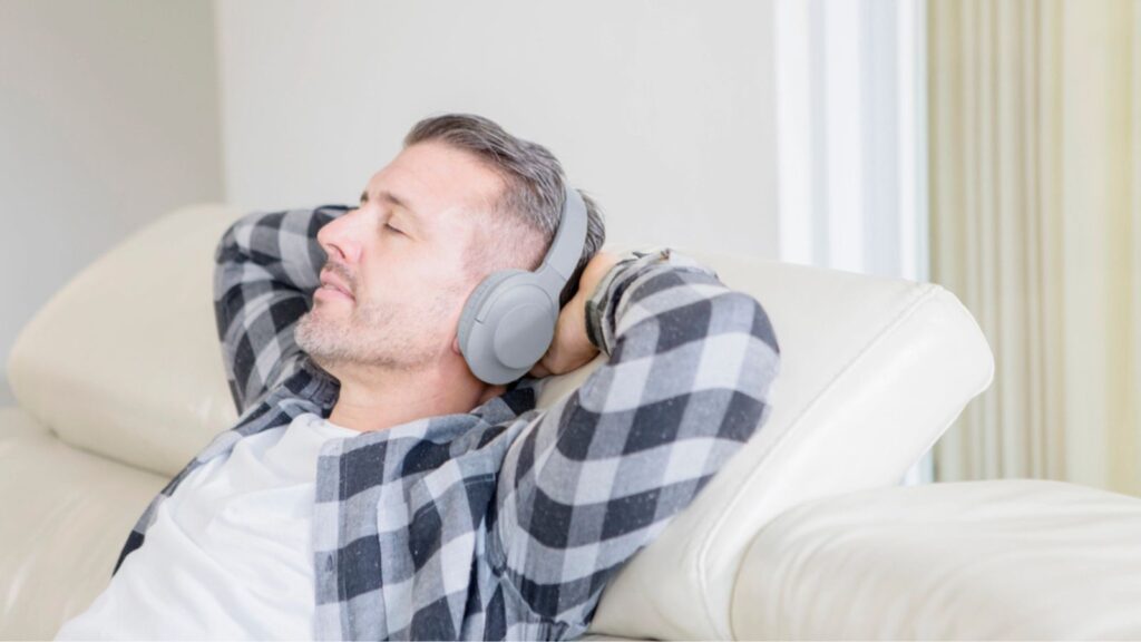 Caucasian man relaxing on sofa with headphones
