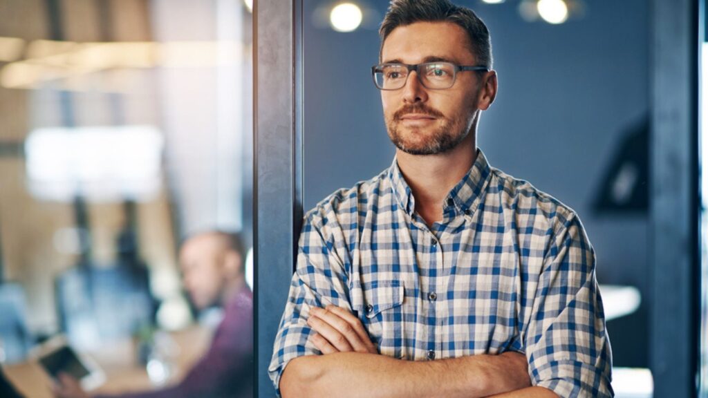 Confident, business and thinking man in office with glasses for ideas, planning and insight for startup company