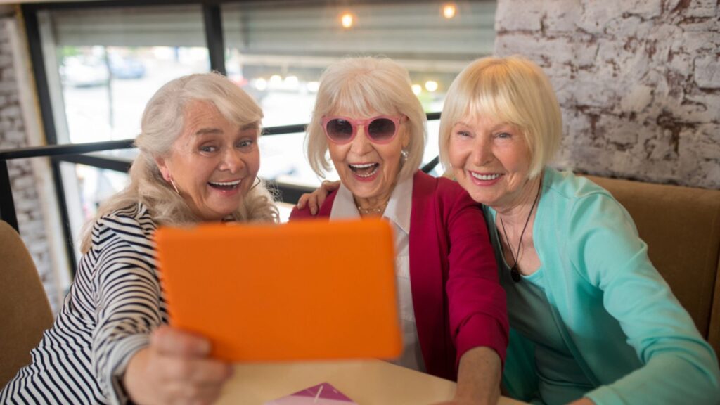 Good-looking old ladies having a video call and looking excited