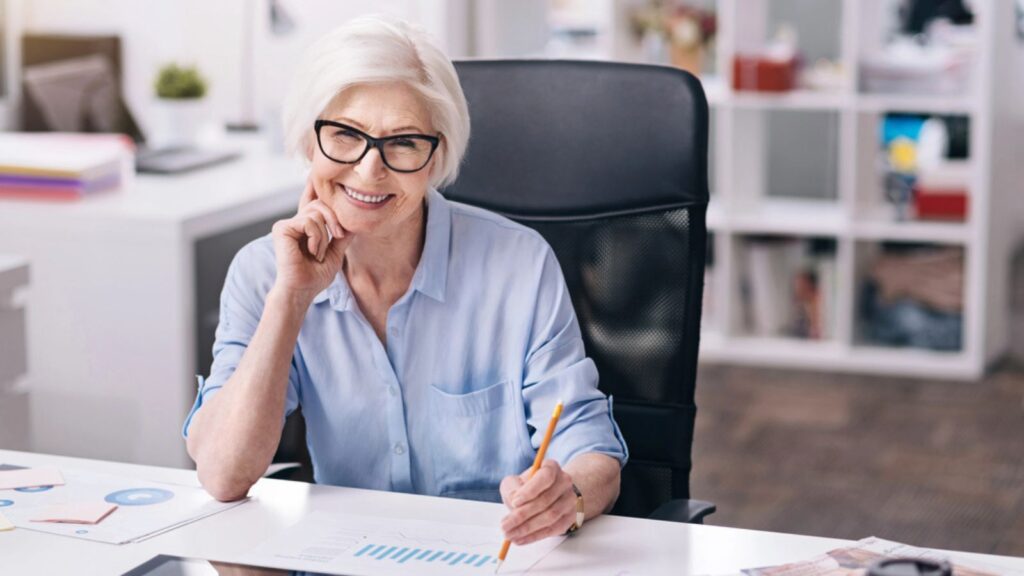 Happy aged businesswoman expressing delight in the business center