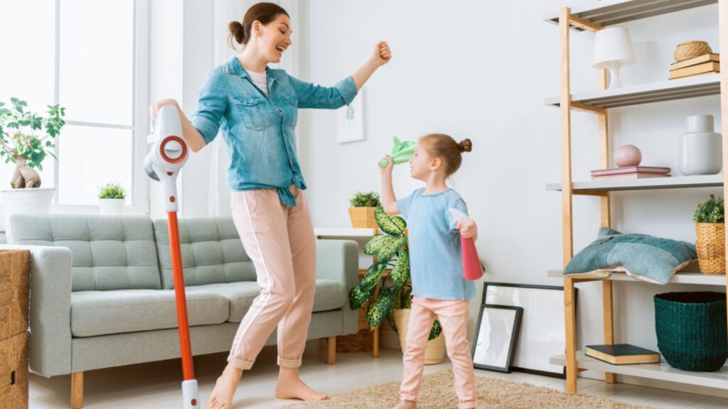 Happy family vacuuming the room. Mother and daughter cleaning