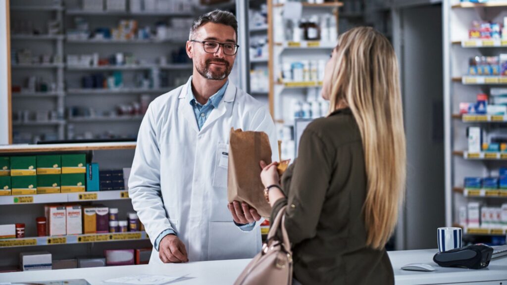 Its her pharmacy of choice. a mature pharmacist assisting a young woman in a chemist