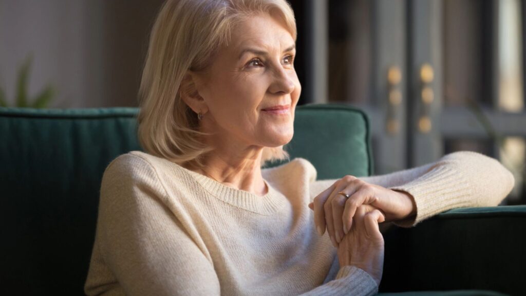 Smiling elderly woman look in distance enjoying pleasant memories