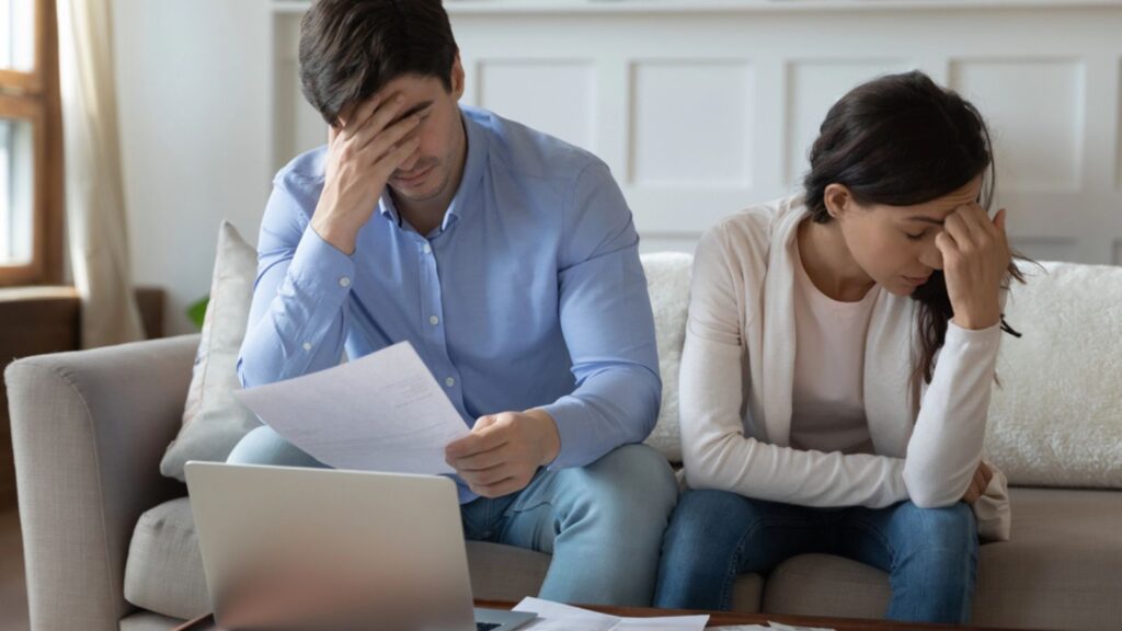 Unhappy young family couple feeling stressed banking money budget finances