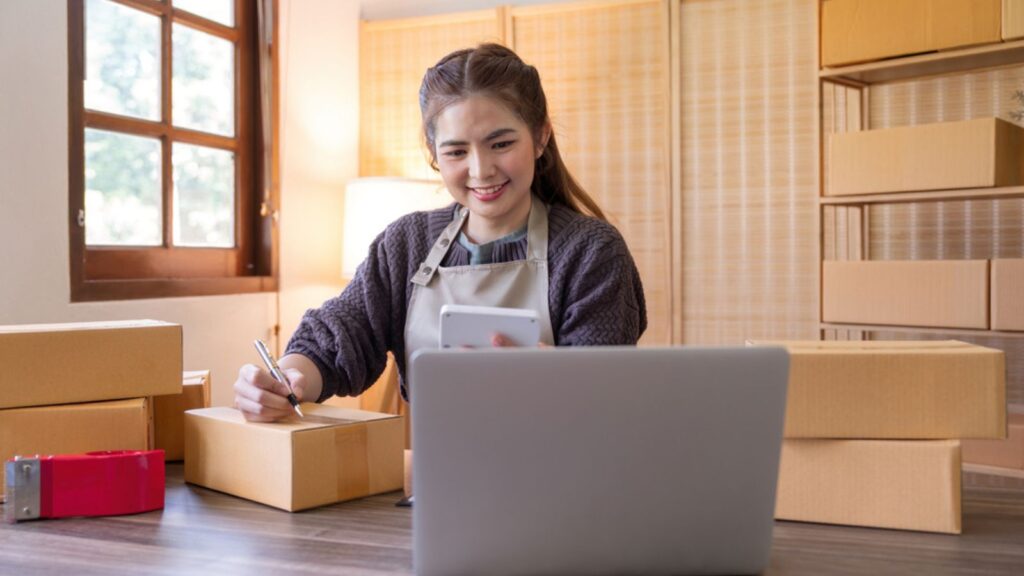 Woman asian is writing a list of customer on paper before shipping to them, she runs an ecommerce business on websites and social media