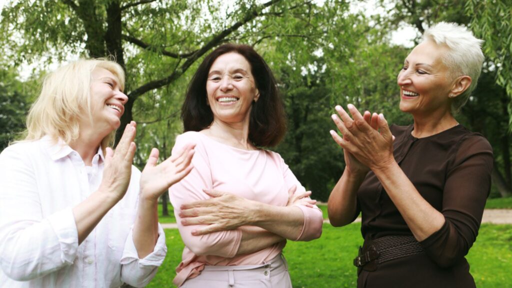 Women friends in the park celebrate a birthday happy old retired