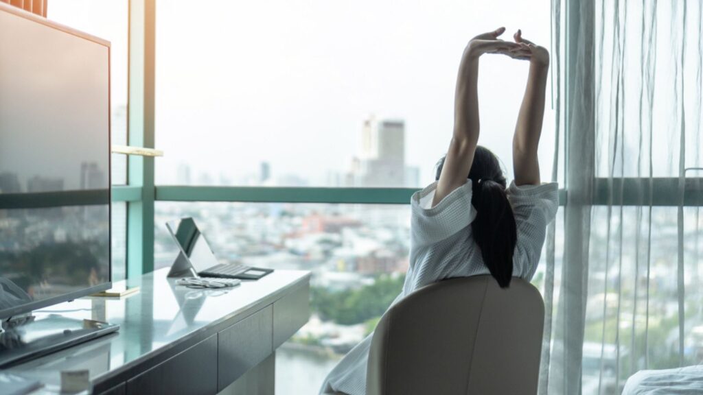 Work-life quality balance concept with happy city lifestyle Asian girl having a good day waking up from sleep in morning taking some rest, in comfort home condominium or hotel bed