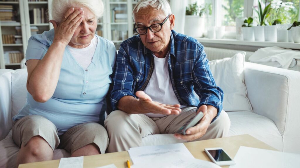 Worried senior couple talking with documents in the table