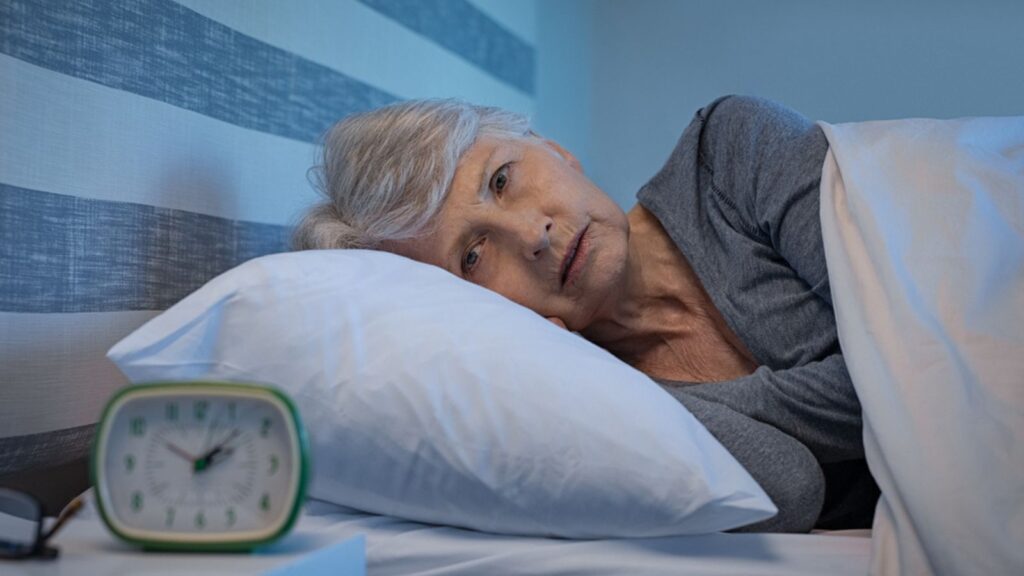 Worried senior woman in bed at night suffering from insomnia