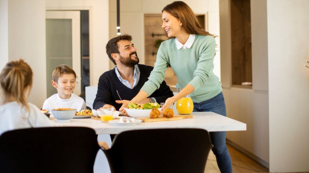 Young mother preparing breakfast for her family in the modern kitchen