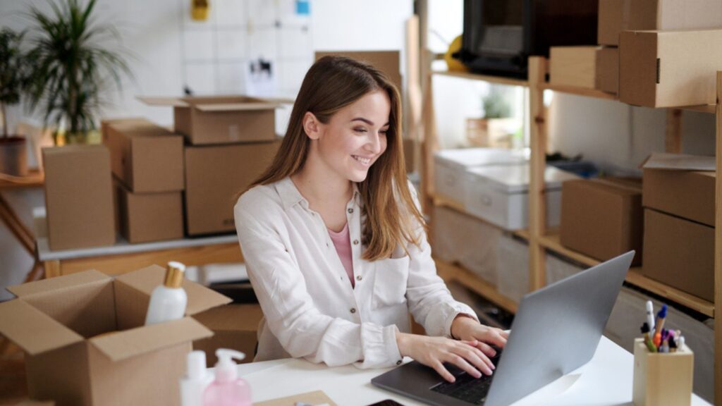 Young woman dropshipper with laptop working at home