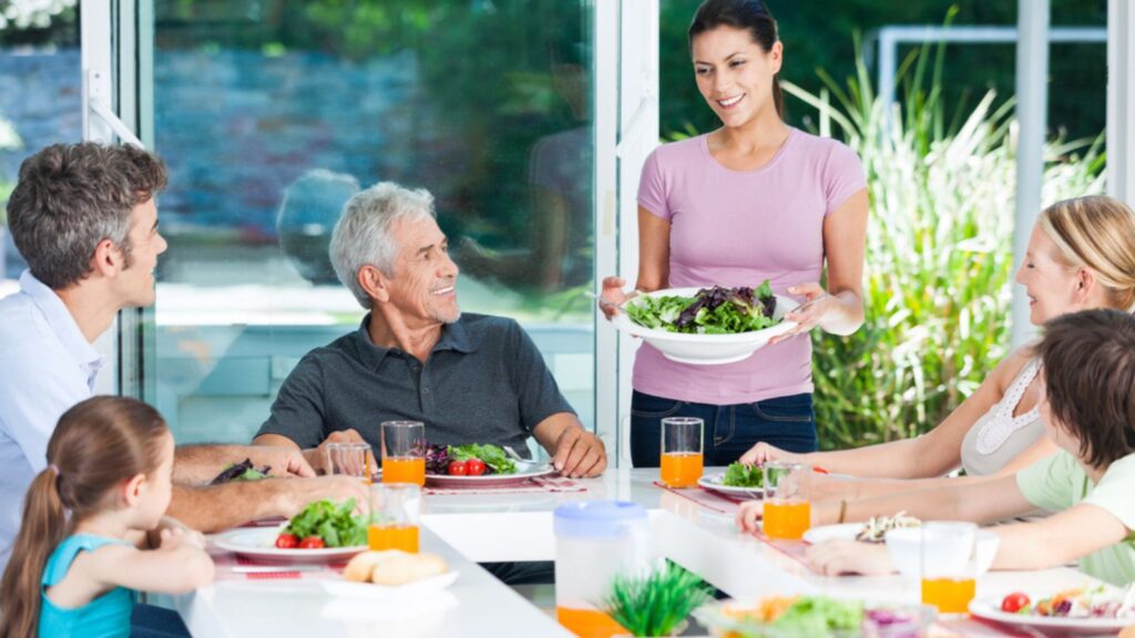 family having lunch dinner eating meal in summertime