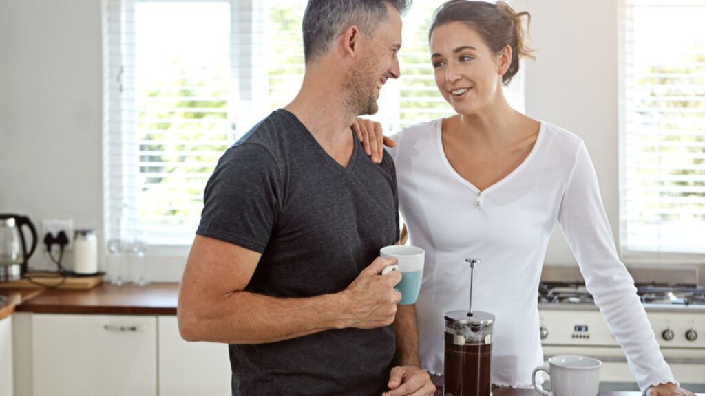 happy couple drinking coffee french press at home