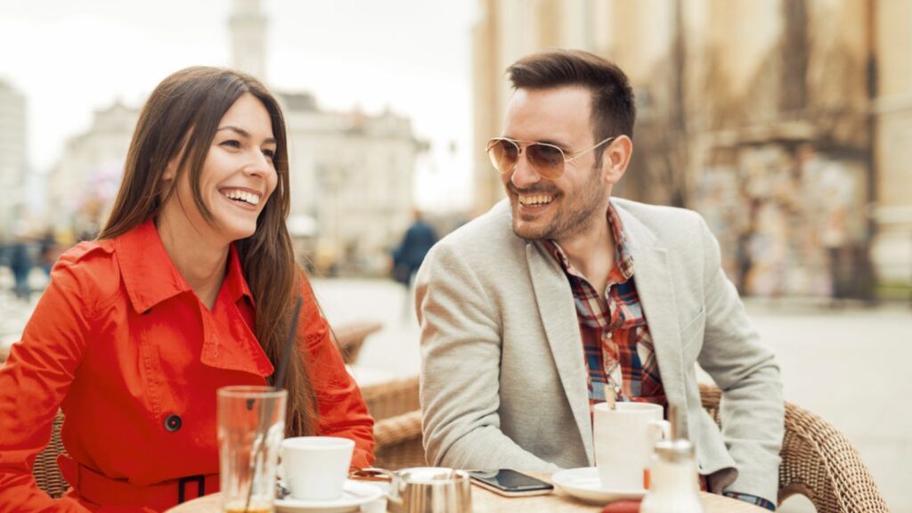 happy smiling laughing couple at cafe coffee restaurant travel