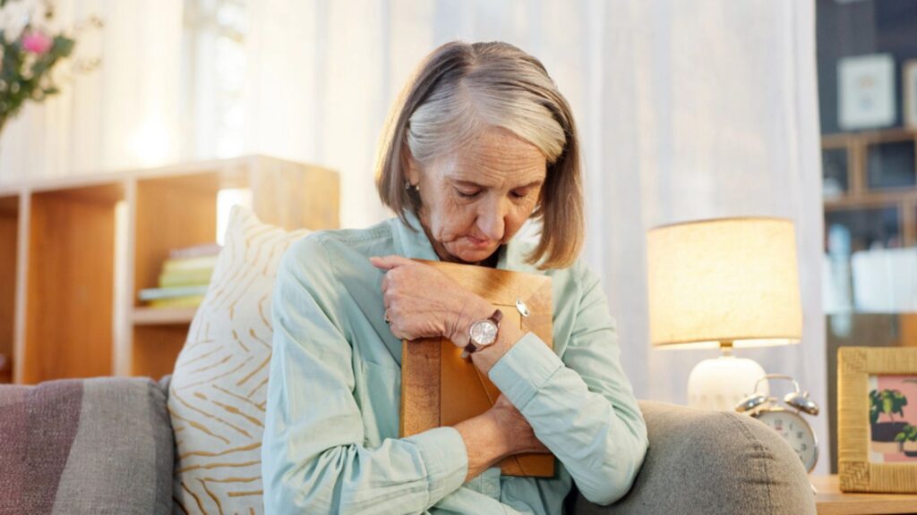 sad depressed grieving old woman holding picture of her dead late husband