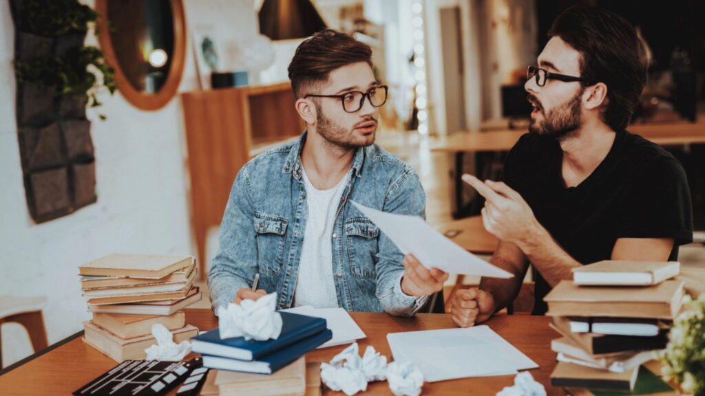 two men studying reading textbook school university discussing history