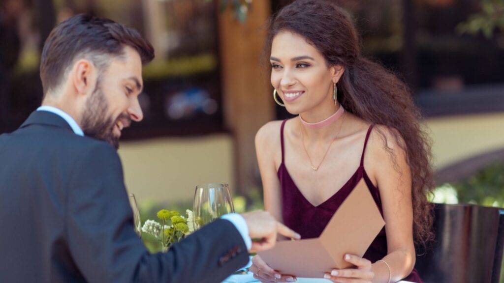 young attractive couple on date at restaurant happy talking